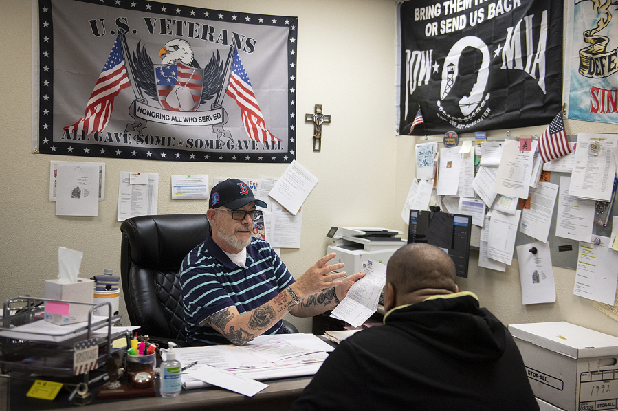 County service officer Mark Kriesen, facing, works with a client at Clark County Veterans Assistance in downtown Vancouver.
