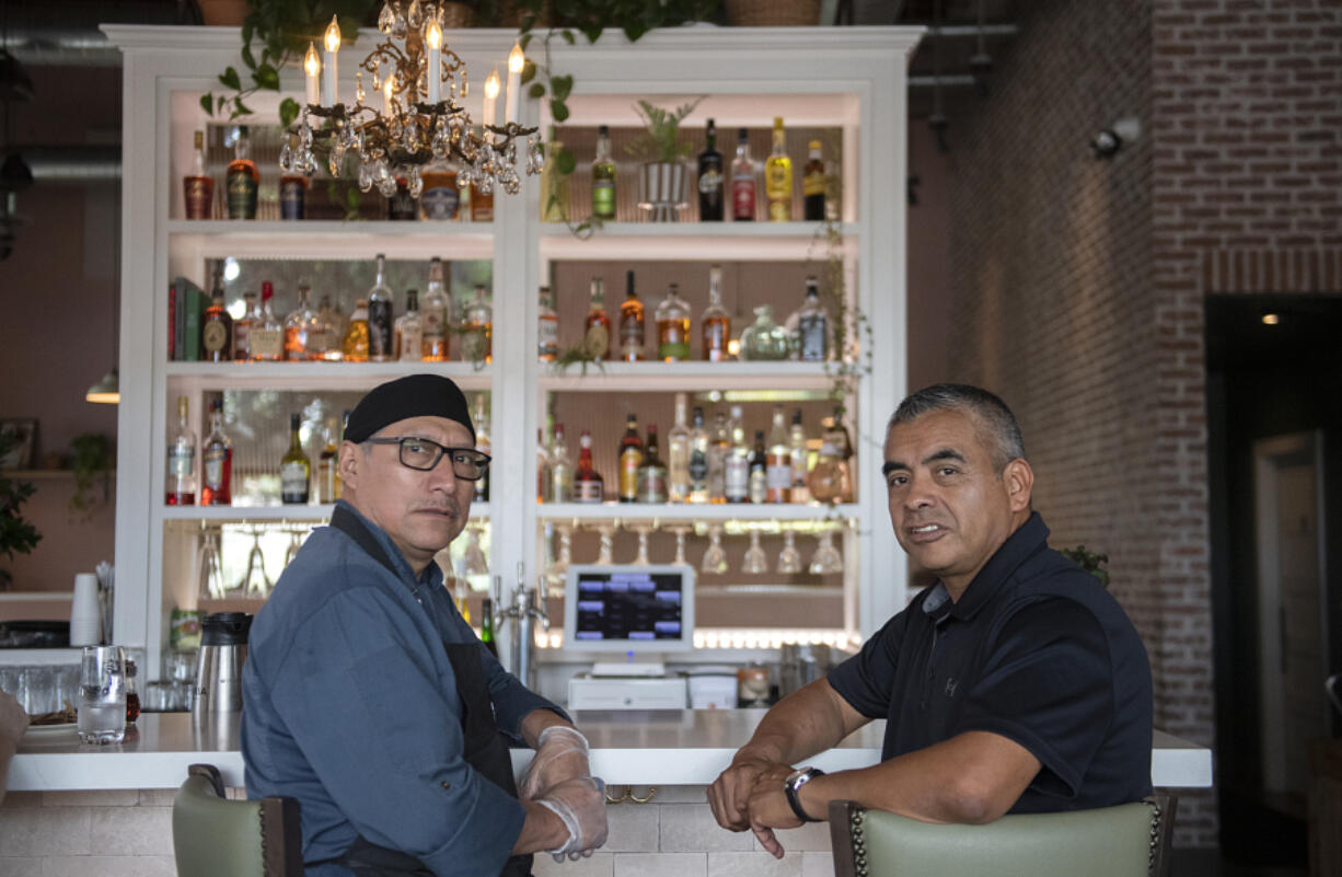 Restaurateurs Jesus Amaro Linares, left, and Genaro Zurita Amaro take a break at the bar in their breakfast restaurant, Cecilia. The brothers-in-law own NW Hospitality Group, which operates four restaurants in greater Vancouver.