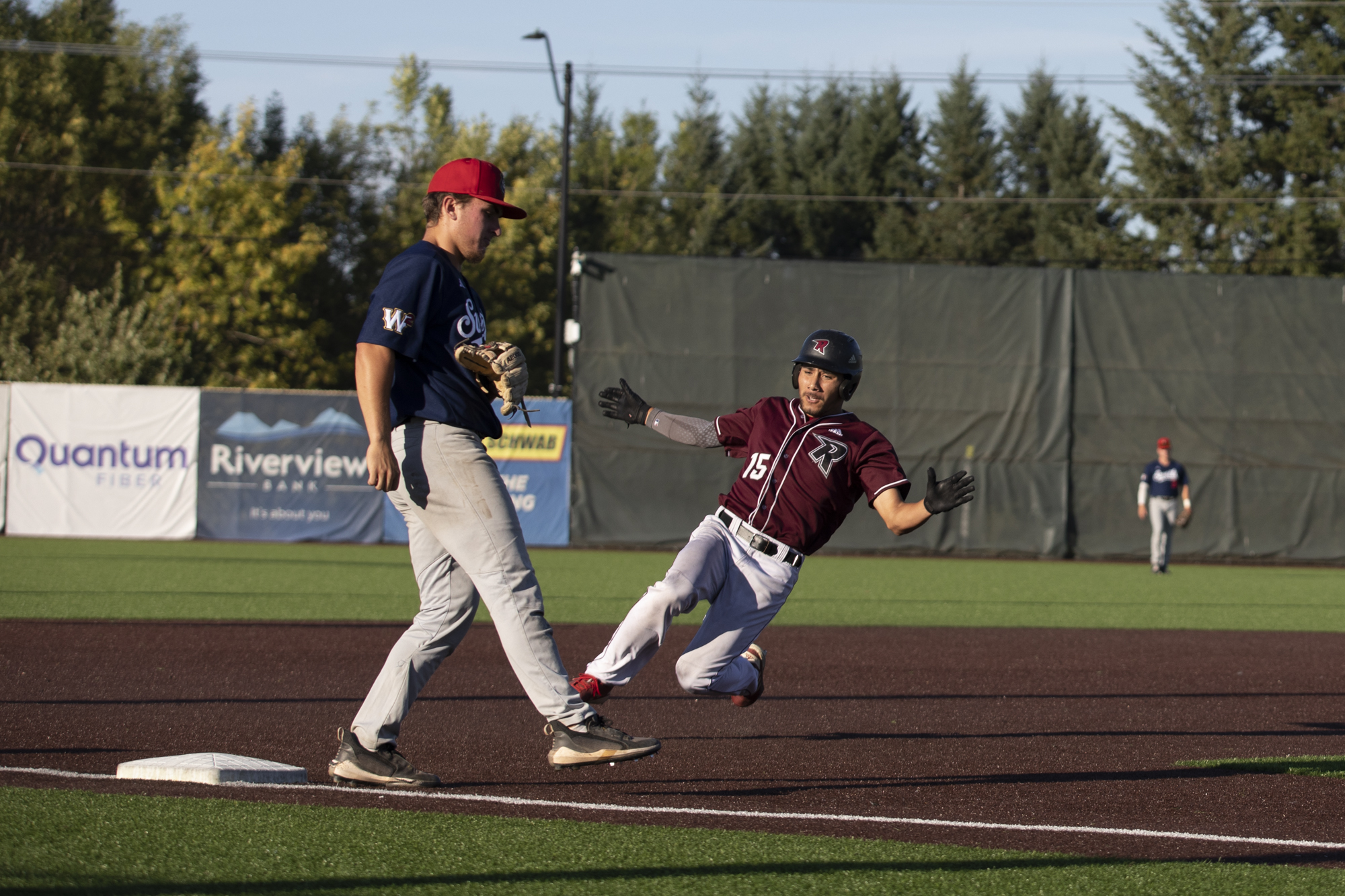 Raptors' Jovan Camacho, right, slides in to third base during the Raptors’ game against the Walla Walla Sweets at the Ridgefield Outdoor Recreation Complex on Thursday, Aug. 3, 2023.