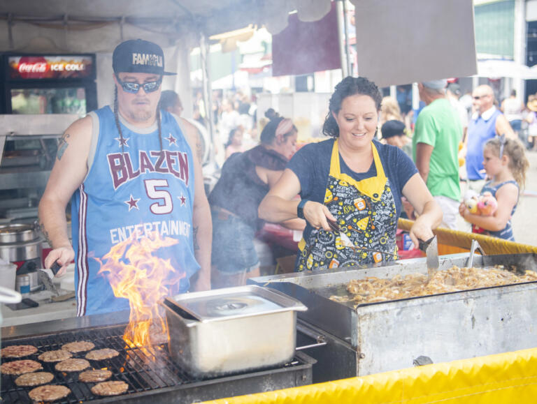 Siblings Harlan Brosa, left, and Bethany Toth work on burger patties and caramelized onions Friday at the Clark County Fair.