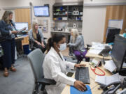 Dr. Neha Didwaniya, foreground center, works at her desk after seeing a patient. She's joined by operations manager Rebecca Hildreth, background from left, medical assistant Abby Pearson and certified nursing assistant Ashlee Harris at Vancouver Clinic's Evergreen Place location. Despite regional health care challenges, Vancouver Clinic has furthered its expansion into Oregon.