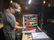 Artist Ron Lee Christianson examines a custom computer case at Blue Horse Studios in Vancouver.
