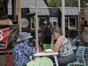 Janie Wood, left, and Karen Lyles, both of Ridgefield, take a break for good food and conversation at Carts by the Park on Wednesday afternoon. The city council held a work session Thursday to consider development regulations specific to food cart pods.
