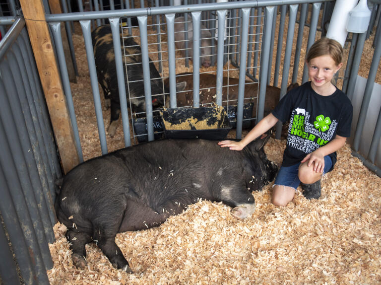 Lillian Marsolek, 8, of Battle Ground, poses for a photo with her pig Proxima on Wednesday, Aug. 9, 2023, at the Clark County Fair.
