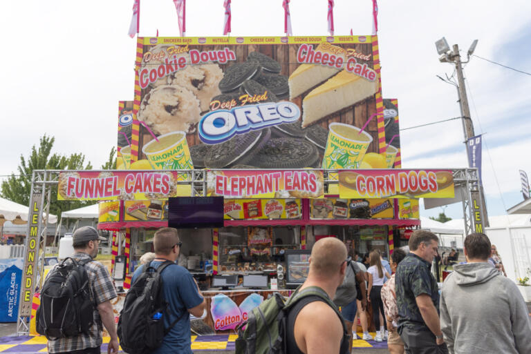 People walk around a food booth Aug. 4 at the Clark County Fair.