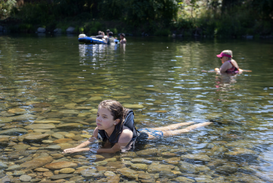 Vika Eykhman, 13, of Vancouver escapes the heat in the cool waters of the Washougal River at the Sandy Swimming Hole on Monday afternoon. Eykhman was one of dozens of locals that sought out the popular spot as a refuge from the high summer temperatures. "It's cold. I just usually get right in," she said.