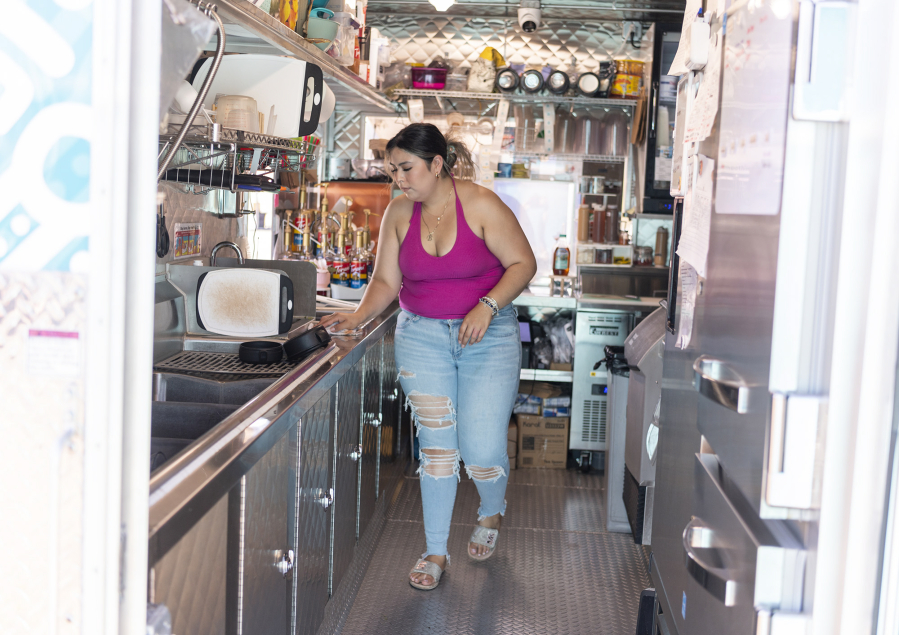 Manager Betzaira Rodriguez cleans up the food cart after a rush Wednesday at the Maya Fruits and Juice Bar food cart on Northeast Andresen Road. Triple-digit temperatures have made operating food carts difficult.