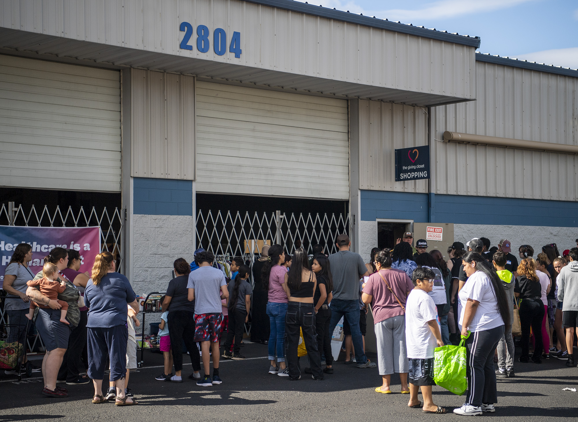 People line up outside Tuesday, Aug. 22, 2023, during a back to school drive at The Giving Closet.