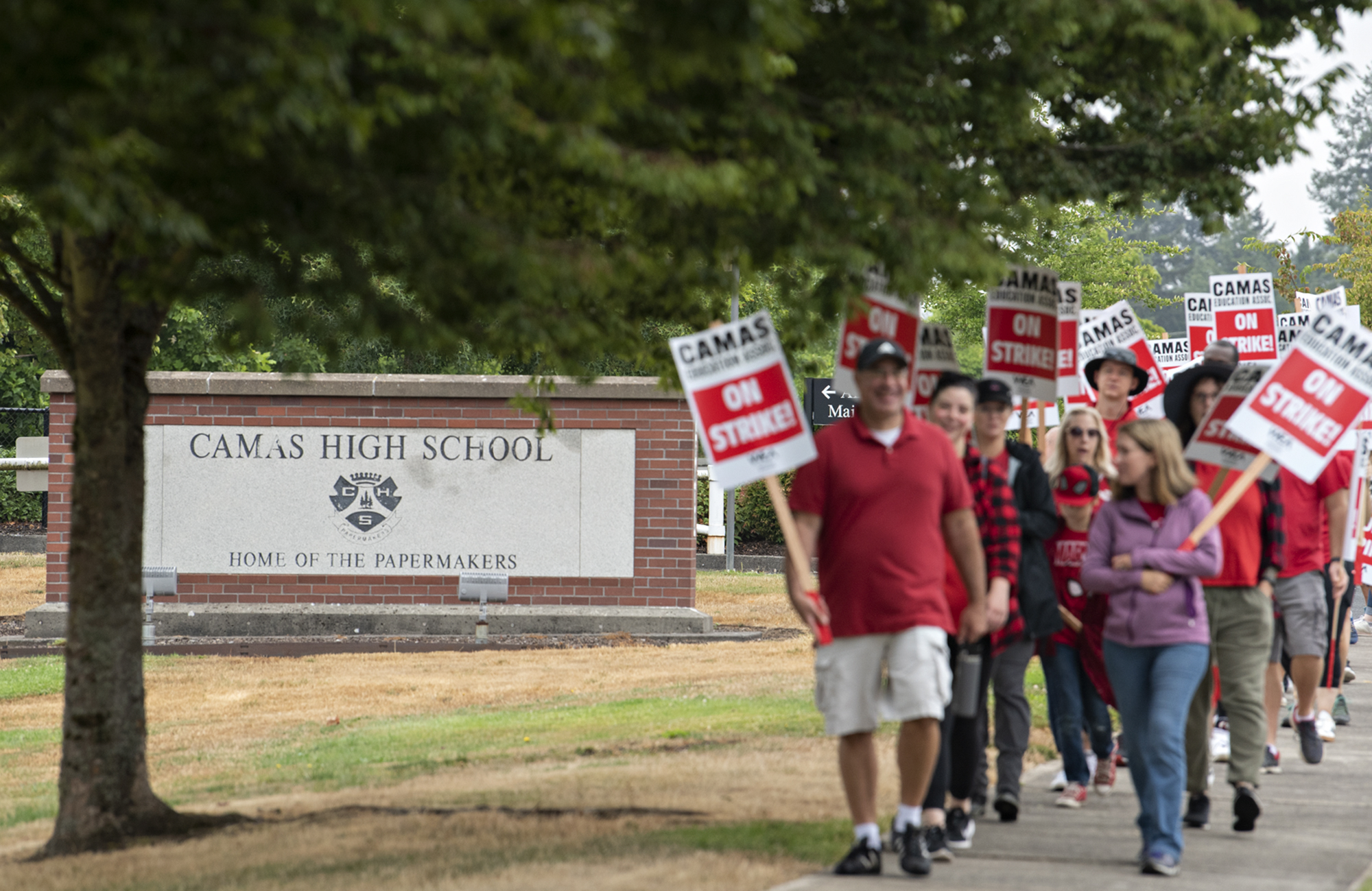 The sign for Camas High School is visible as teachers and supporters join a district wide strike outside the school Monday morning, Aug. 28, 2023. The strike postponed the first day of school in the district.