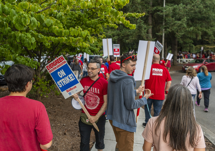 Evergreen Education Association members walk around Tuesday during a sign-making rally at Leroy Haagen Memorial Community Park. Schools are closed Aug. 30 due to the looming strike, according to the Evergreen Public Schools website.