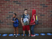 Third graders from left, MJ Mefy, Landon Huffman and Jasper McCann line up for the start of the school day at Harney Elementary.