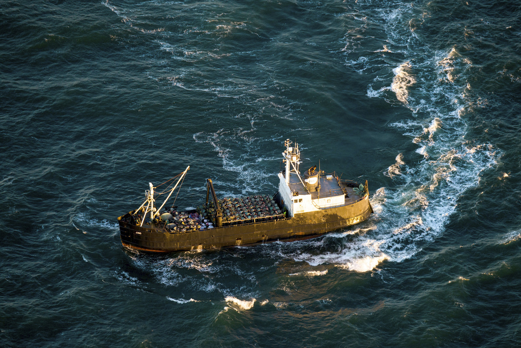 FILE - A crabbing vessel turns below a U.S. Coast Guard flyover inspection of crabbing ships along the Washington and Oregon coasts near Astoria, Ore., on Jan. 1, 2016. Oregon crab fishermen may soon face an indefinite extension of rules that for three seasons have restricted the number of pots allowed in the water to reduce the risk of whales and sea turtles getting entangled in fishing gear.