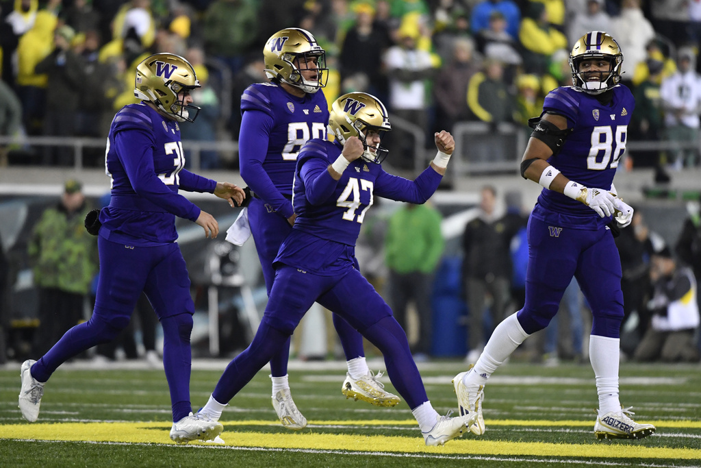FILE -Washington placekicker Peyton Henry (47) celebrates ith punter Jack McCallister (38), tight end Quentin Moore (88) and long snapper Jaden Green (89) after making a field goal during the second half of an NCAA college football game against Oregon, Saturday, Nov. 12, 2022, in Eugene, Ore. The Big Ten has cleared the way for Oregon and Washington to apply for membership, four people familiar with the negotiations told The Associated Press., Friday, Aug.