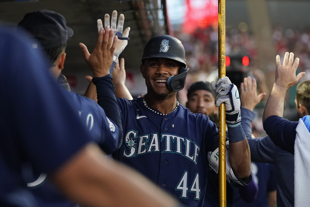 Seattle Mariners' Julio Rodriguez (44) celebrates in the dugout after hitting a home run during the fourth inning of a baseball game against the Los Angeles Angels in Anaheim, Calif., Friday, Aug. 4, 2023. J.P. Crawford also scored.