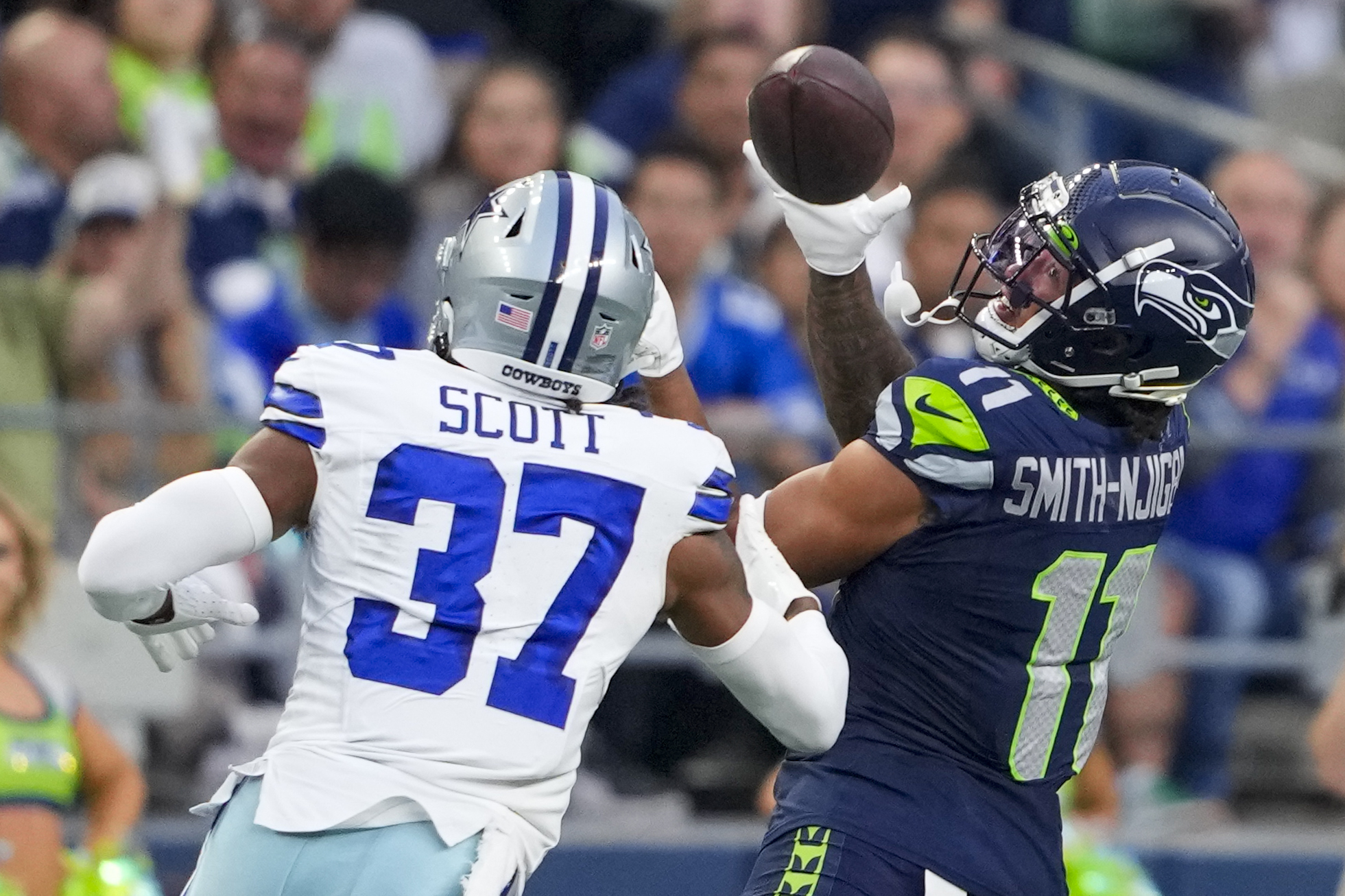 Seattle Seahawks wide receiver Jaxon Smith-Njigba catches a pass in front of Dallas Cowboys cornerback Eric Scott Jr. during the first half of a preseason NFL football game Saturday, Aug. 19, 2023, in Seattle.