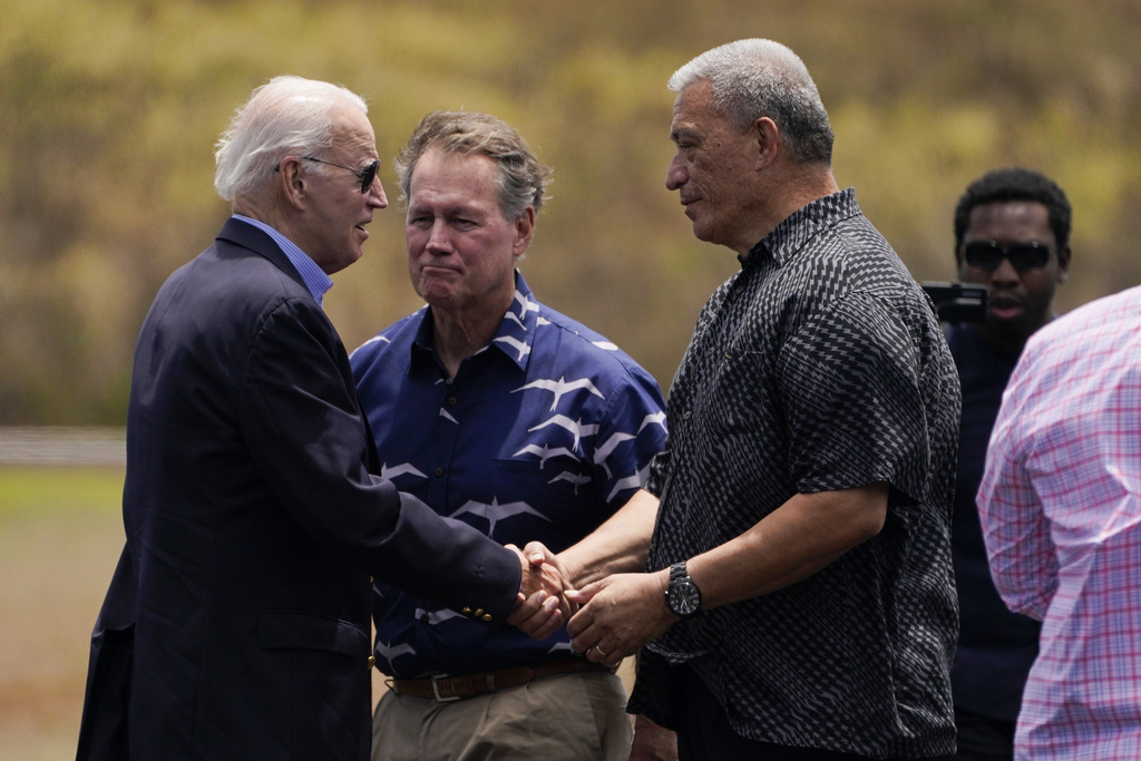 President Joe Biden greets Maui Country Mayor Richard Bissen at Kapalua Airportas he visits areas devastated by the Maui wildfires, Monday, Aug. 21, 2023, in Lahaina, Hawaii. In the center is Rep. Ed Case, D-Hawaii.