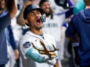 Seattle Mariners' Julio Rodriguez points a trident in the dugout as he celebrates a two-run home run to score J.P. Crawford against the Oakland Athletics during the fourth inning of a baseball game, Monday, Aug. 28, 2023, in Seattle.