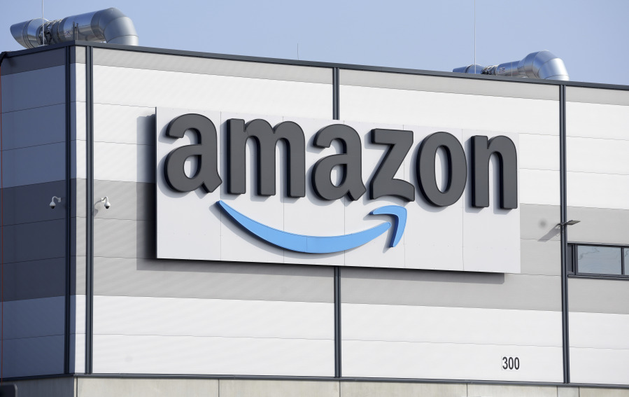 FILE - An Amazon company logo marks the facade of a building in Schoenefeld near Berlin, March 18, 2022. Amazon will impose new fees on third-party sellers who ship their products to customers instead of using the company's fulfillment service.
