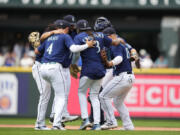 Seattle Mariners' Josh Rojas (4), J.P. Crawford (3), Ty France (23) and others celebrate a 5-4 win over the Oakland Athletics in a baseball game Wednesday, Aug. 30, 2023, in Seattle.