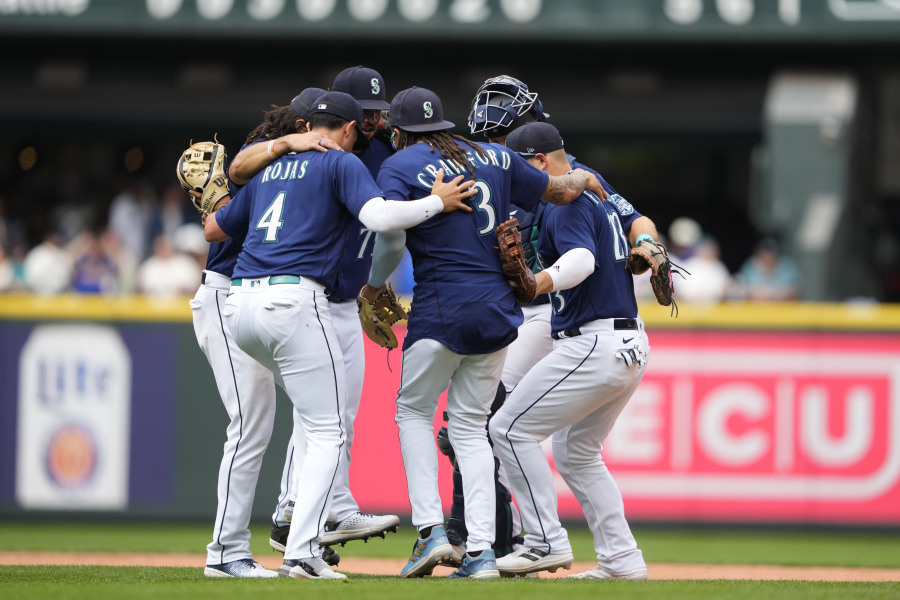 Seattle Mariners' Josh Rojas (4), J.P. Crawford (3), Ty France (23) and others celebrate a 5-4 win over the Oakland Athletics in a baseball game Wednesday, Aug. 30, 2023, in Seattle.