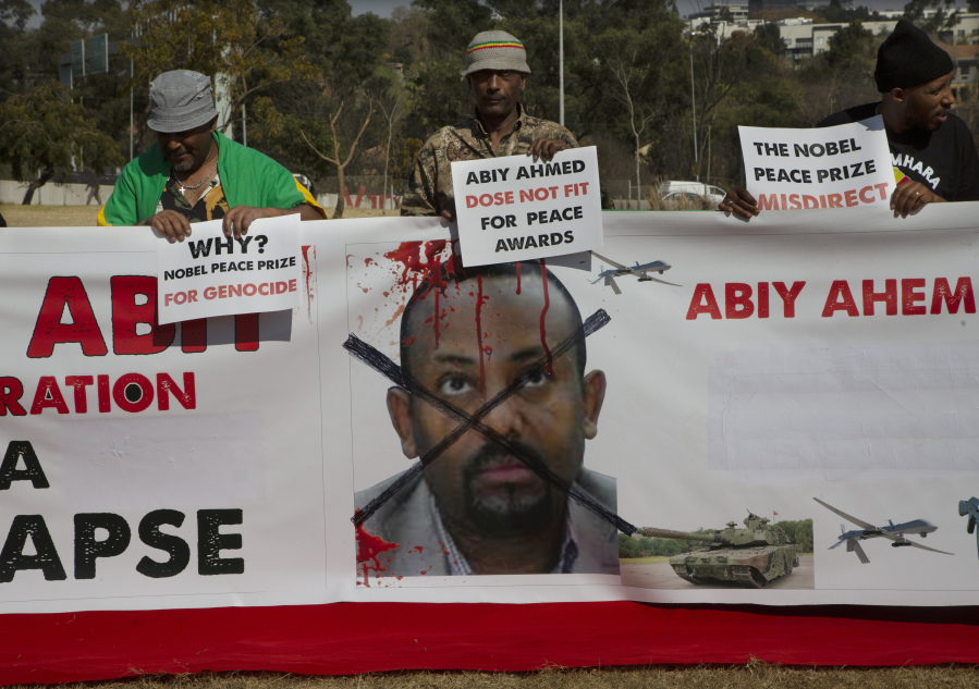 Ethiopians carry placards as they protest near the venue of the BRICS Summit in Sandton, Johannesburg, Tuesday, Aug. 22, 2023. Russian President Vladimir Putin will be notably absent when Chinese President Xi Jinping and other leaders from the BRICS group of emerging economies begin a three-day summit in South Africa.