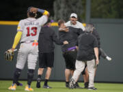 Field guards haul away one of two fans who approached Atlanta Braves right fielder Ronald Acuna Jr. (13) before the bottom of the seventh inning of a baseball game against the Colorado Rockies, Monday, Aug. 28, 2023, in Denver.