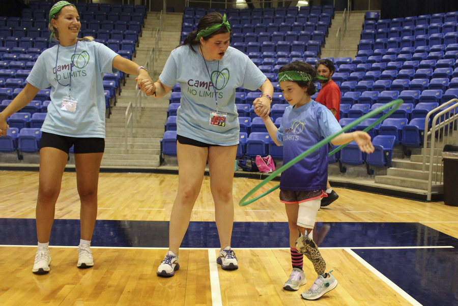Anya Rhodes, 8, of Newton Mass., right, plays a game with a hula hoop July 14 during Camp No Limits at Quinnipiac University in Hamden, Conn.