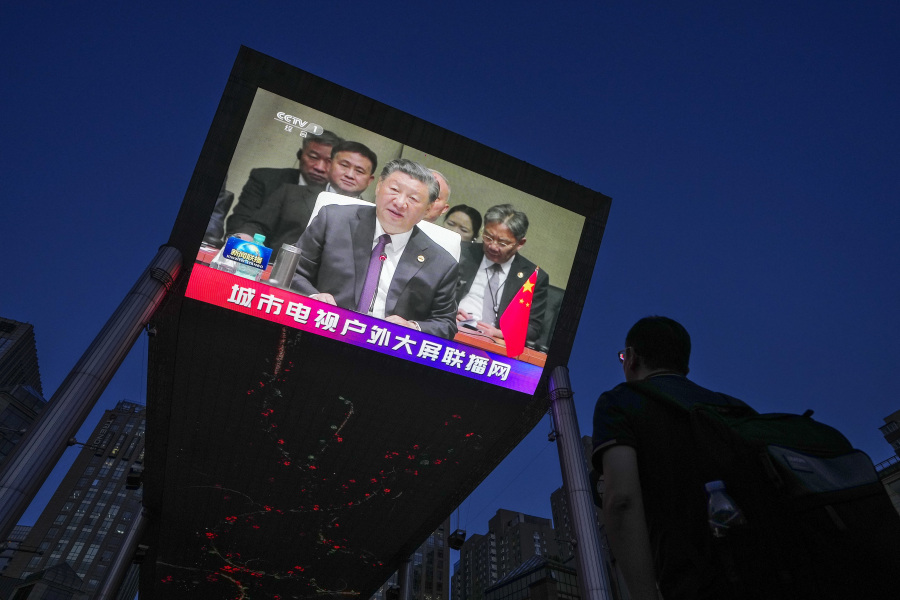 A man watches a large screen showing CCTV broadcasting news of Chinese President Xi Jinping delivers his speech at the BRICS Summit held in South Africa, at an outdoor shopping mall in Beijing, Thursday, Aug. 24, 2023. Iran and Saudi Arabia were among six countries set to join Brazil, Russia, India, China and South Africa in the BRICS economic bloc from next year, the bloc announced Thursday, a move that will likely throw more scrutiny on Beijing's political influence in the Persian Gulf.