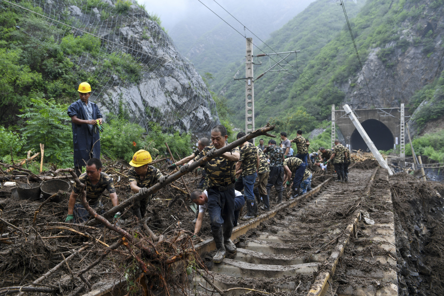 In this photo released by Xinhua News Agency, workers remove fallen debris from a railway track at a flood hit Village in Mentougou district on the outskirts of Beijing on Tuesday, Aug. 1, 2023. China's capital has recorded its heaviest rainfall in at least 140 years over the past few days after being deluged with heavy rains from the remnants of Typhoon Doksuri.