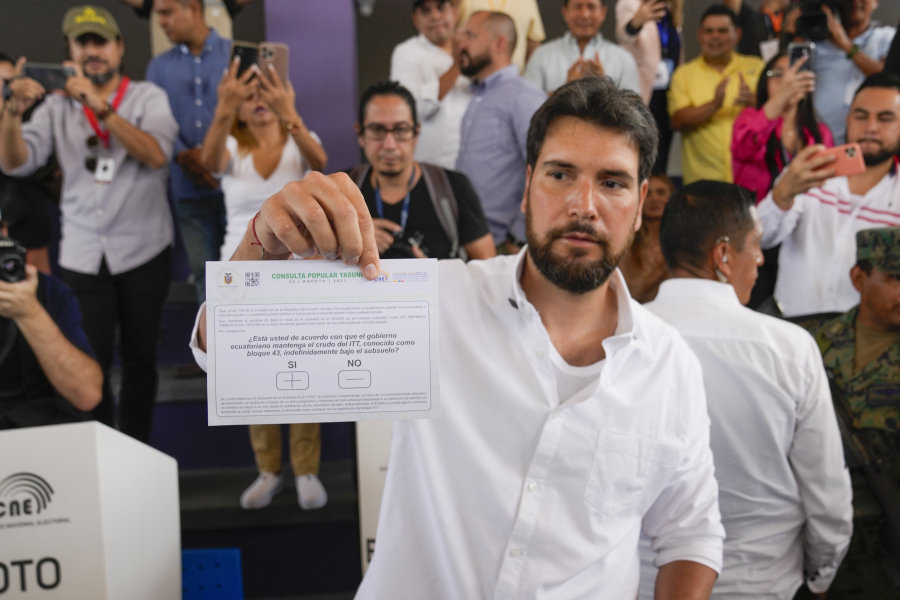 Presidential candidate Jan Topic, of the Country Without Fear Coalition, shows his ballot in a referendum on whether the country should ban oil operations in the Amazons in Guayaquil, Ecuador, Sunday.