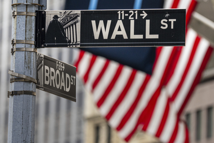 Street signs at the center of the New York City financial district frame the U.S. Flags flying from the front of the New York Stock Exchange, Wednesday, Aug. 16, 2023. Wall Street is drifting Wednesday and stocks are mixed a day after their latest tumble in what's been a messy August. (AP Photo/J.