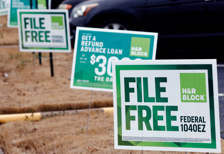 FILE- In this Feb. 14, 2018, file photo, H&R Block signs are displayed in Jackson, Miss. Congressional Democrats are accusing big tax preparation firms including Intuit and H&R Block of undermining the federal government's upcoming electronic free-file tax return system, and are demanding lobbying, hiring and revenue data to determine what's going on. (AP Photo/Rogelio V.