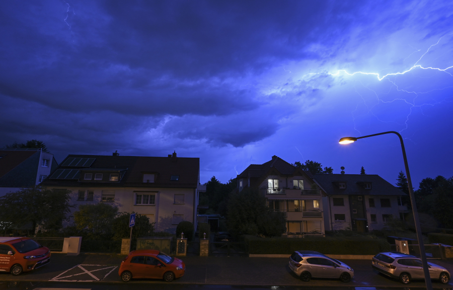 In this shot with slow shutter speed, lightning discharges in the evening sky during a heavy thunderstorm over the houses in the district of Sachsenhausen, Frankfurt/Main, Germany Wednesday, Aug. 16, 2023. Heavy rain in parts of Germany caused flooding and led to dozens of flight cancelations at Frankfurt Airport, the country's busiest and a major European hub, authorities said Thursday.