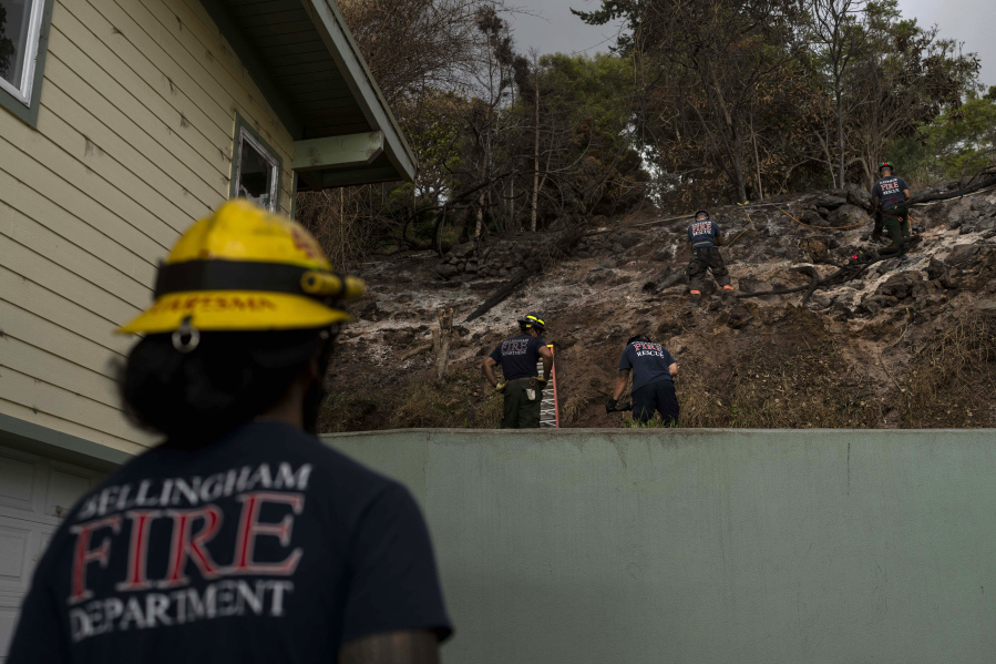 Firefighters clear debris in Kula, Hawaii, Tuesday, Aug. 15, 2023, following wildfires that devastated parts of the Hawaiian island of Maui. (AP Photo/Jae C.
