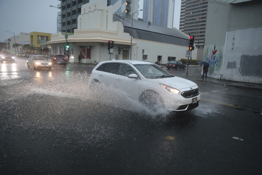 A car turns onto flooded Cooke Street Dec. 6, 2021, in Honolulu.
