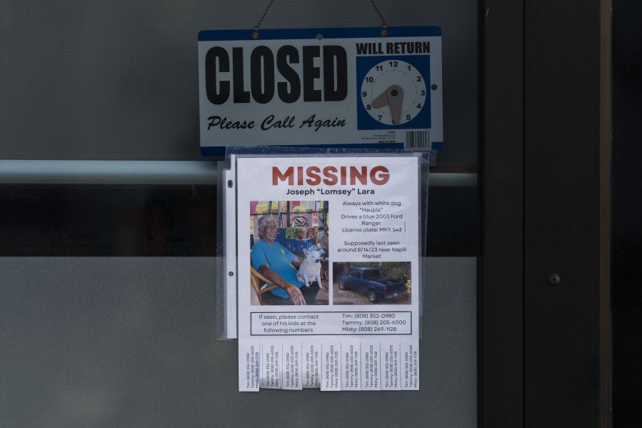 A missing person flyer for Joseph "Lomsey" Lara is posted on the door of a business in a shopping mall in Lahaina, Hawaii, Monday, Aug. 21, 2023. Wildfires devastated parts of the Hawaiian island of Maui earlier this month. (AP Photo/Jae C.