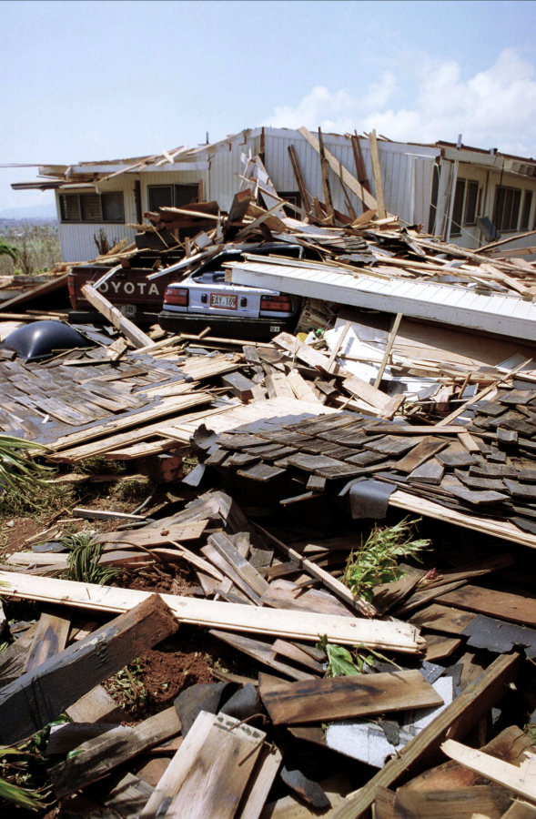 FILE - A car and a pickup truck are buried in the rubble of what was once a home on the island of Kauai, on Sept. 14, 1992. Two-thirds of the single family homes on Hawaii's most populous island have no hurricane protections. This year's return of El Nino is highlighting this weakness because it boosts the odds that more tropical cyclones will travel through Hawaii's waters this summer and fall.