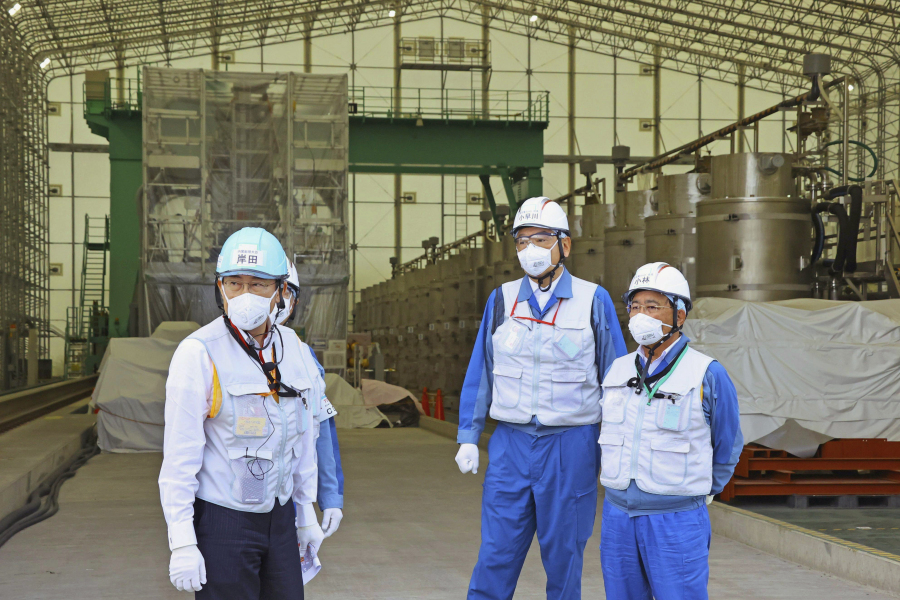 Japanese Prime Minister Fumio Kishida, left, along with Tomoaki Kobayakawa, president of Tokyo Electric Power Co. (TEPCO), second right, and Yoshimitsu Kobayashi, chairman of TEPCO, visits a facility to treat radioactive wastewater at the tsunami-wrecked Fukushima Daiichi nuclear power plant in Okuma town, northeastern Japan, Sunday, Aug. 20, 2023. Kishida made a brief visit to the power plant on Sunday to highlight the safety of an impending release of treated radioactive wastewater into the Pacific Ocean, a divisive plan that his government wants to start soon despite protests at home and abroad.