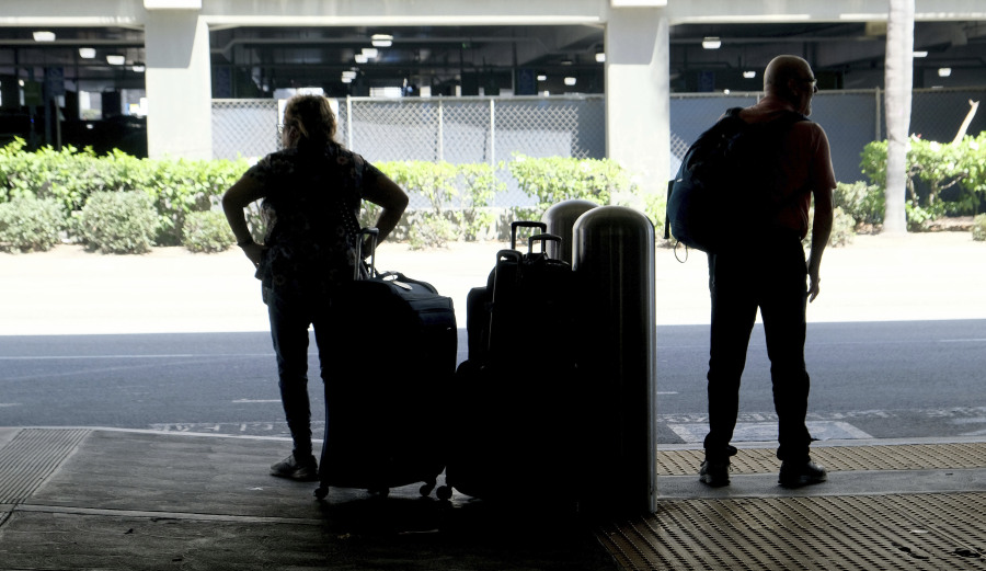 A couple waits for transportation at Terminal 5 at LAX on Wednesday, Aug. 30, 2023, in Los Angeles. With Labor Day weekend just days away, airports and roadways are expected to be busy as tens of thousands of Southern Californians travel out of town.
