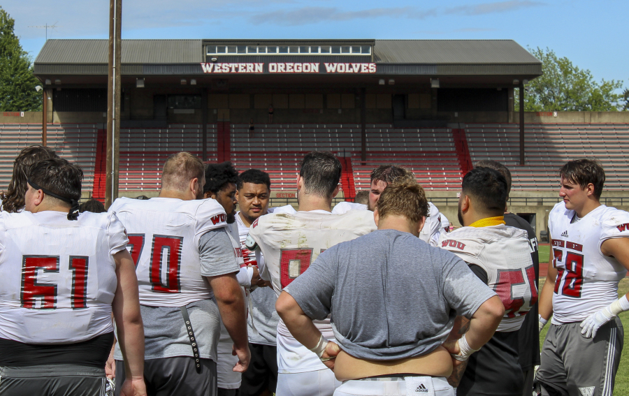 Western Oregon players gather during NCAA college football practice, Wednesday, Aug. 9, 2023, in Monmouth, Ore. As one of just two Division II schools with football teams in on the West Coast, Western Oregon spends hundreds of thousands of dollars in travel expenses to compete in the Lone Star Conference against schools in Texas and New Mexico.