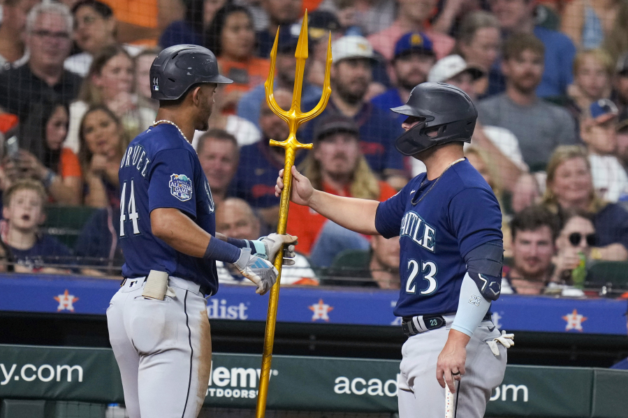 Seattle Mariners' Julio Rodriguez, left, is given a trident by Ty France after Rodriguez's solo home run against the Houston Astros during the third inning of a baseball game Friday, Aug. 18, 2023, in Houston.