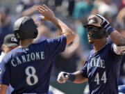Seattle Mariners' Julio Rodriguez (44) celebrates with Dominic Canzone (8) after hitting a three-run home run during the eighth inning of a baseball game against the Kansas City Royals Thursday, Aug. 17, 2023, in Kansas City, Mo.