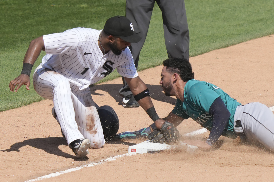 Seattle Mariners' Jose Caballero steals third as Chicago White Sox third baseman Elvis Andrus applies a late tag during the seventh inning of a baseball game Wednesday, Aug. 23, 2023, in Chicago.