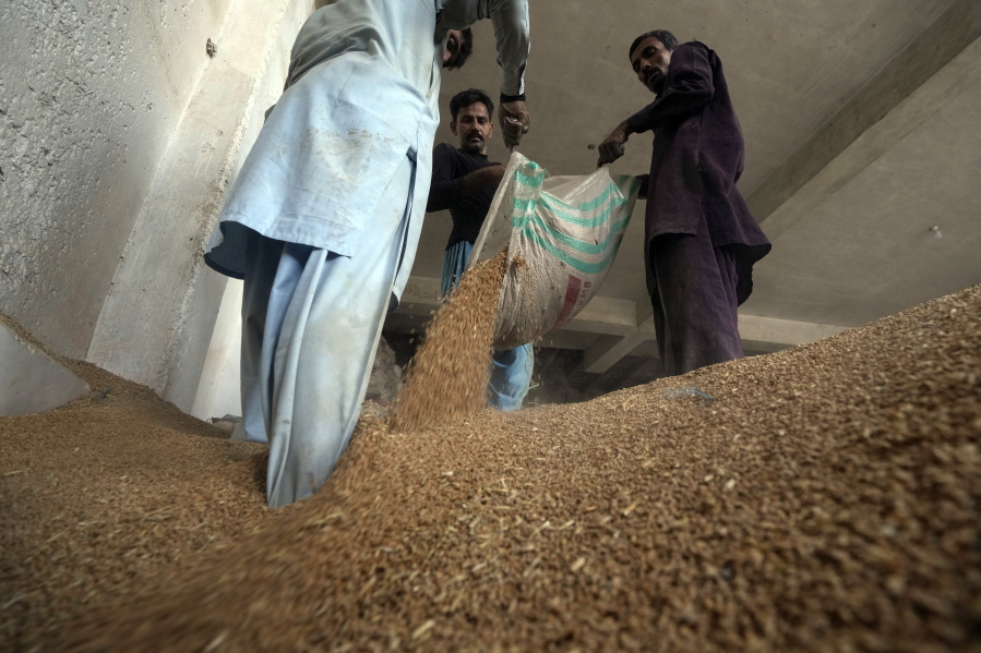 Pakistani workers sort the wheat in a warehouse in Karachi, Pakistan, on Wednesday, July 26, 2023.