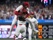 Philadelphia Phillies pitcher Michael Lorenzen, left, and J.T. Realmuto celebrate after Lorenzen's no-hitter during a baseball game against the Washington Nationals, Wednesday, Aug. 9, 2023, in Philadelphia.
