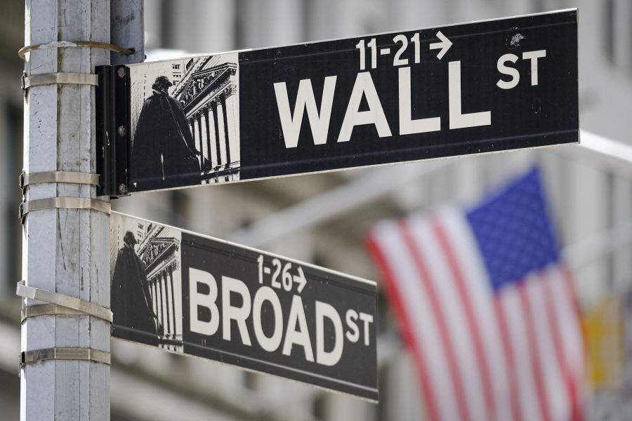 A U.S. Flag hangs in the background at the corner of Wall and Broad Streets in the heart of the Financial District in New York City, Tuesday, Aug. 1, 2023. Stocks are taking a step back Tuesday from their big surge for the year so far following a mixed set of earnings reports from U.S. companies. (AP Photo/J.