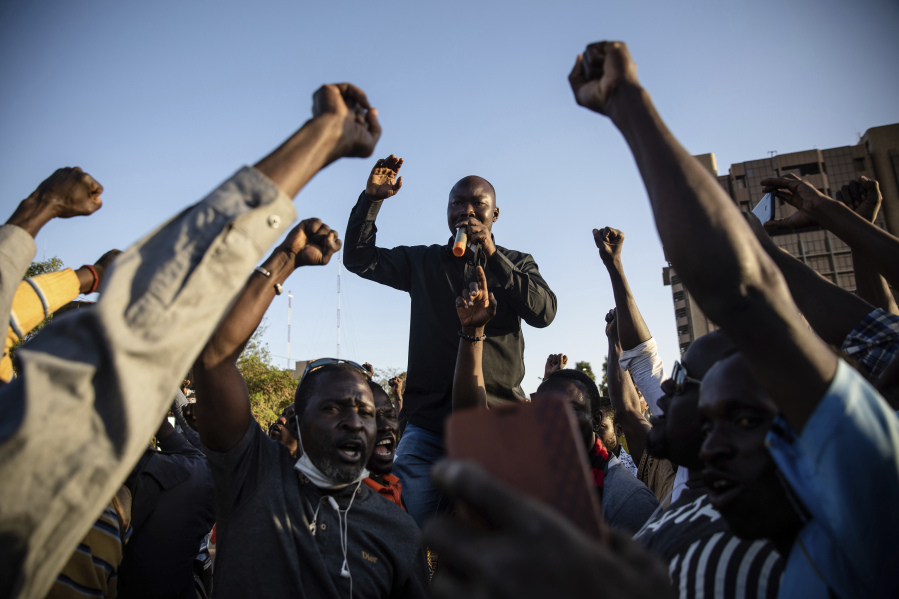 FILE - Activist Mamadou Drabo, leader of the Save Burkina Faso movement, announces to the crowd gathered Place de la Nation that Lt. Col. Paul Henri Sandaogo Damiba has taken the reins of the country in Ouagadougou, Burkina Faso, Monday, Jan. 24, 2022. Not everyone is hostile to last week's coup in Niger. Neighboring Burkina Faso and Mali have taken the unusual step of declaring that foreign military intervention in Niger would be a declaration of war against them, too. Both have had coups in recent years.