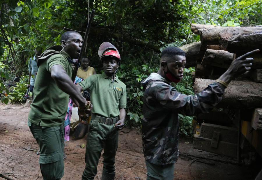 Three rangers argue with illegal loggers near a truck carrying timber inside the Omo Forest Reserve in Nigeria on Wednesday, Aug. 2, 2023. Conservationists and rangers blame the government for not enforcing environmental regulations or adequately replanting trees, impeding Nigeria's pledge under the Paris climate agreement to maintain places like forests that absorb carbon from the atmosphere.
