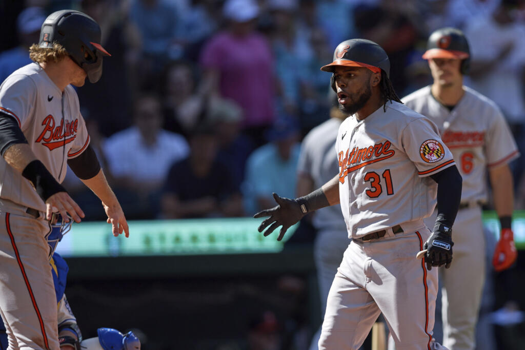 Baltimore Orioles' Cedric Mullins (31) celebrates as he greets Gunnar Henderson, left, after they both scored on his two-run home run against the Seattle Mariners during the 10th inning a baseball game, Sunday, Aug. 13, 2023, in Seattle.