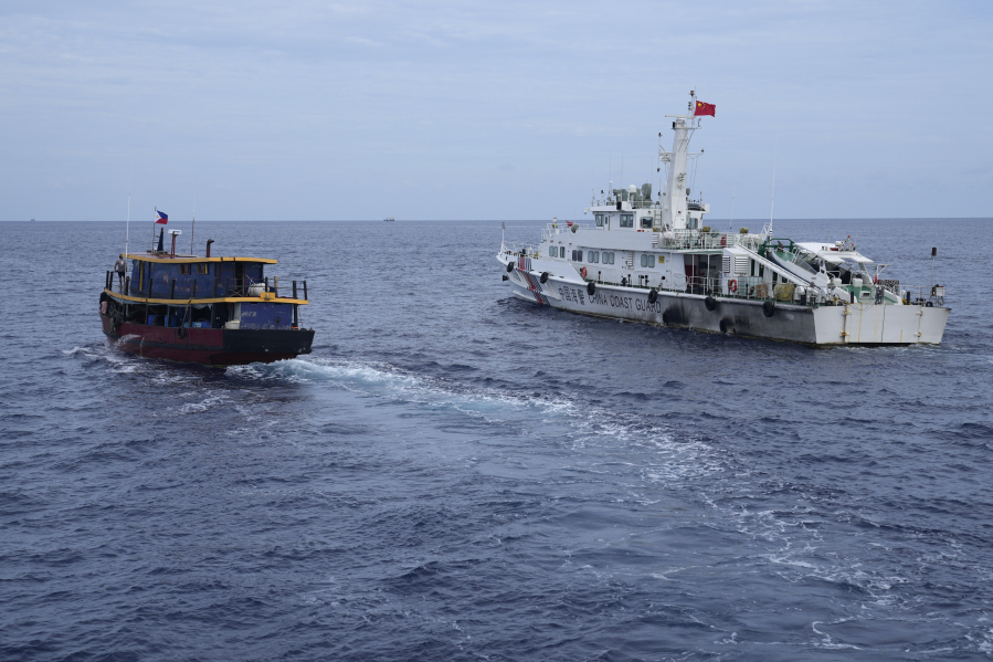 A Philippine supply boat, left, tries to evade a Chinese coast guard ship off Second Thomas Shoal, locally known as Ayungin Shoal, at the disputed South China Sea during a rotation and resupply mission on Tuesday, Aug. 22, 2023. As a U.S. Navy plane circled overhead, two Philippine navy-manned boats manage to breach through a Chinese coast guard blockade in a dangerous confrontation in the disputed South China Sea and succeeded in delivering food and other supplies to Filipino forces guarding a contested shoal on board BRP Sierra Madre.
